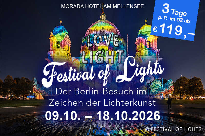 Ein ruhiger See mit Wolkenspiegelungen und überhängenden Ästen am Ufer.