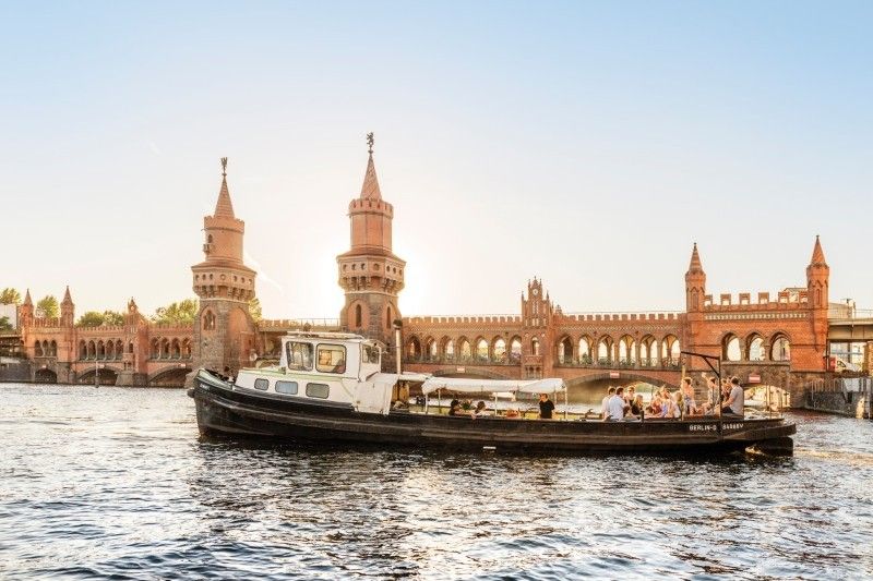 Boot auf der Spree vor der Oberbaumbrücke bei Sonnenuntergang